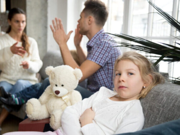 Little sad girl depressed with parents arguments, frustrated daughter feels upset offended while mom and dad fighting at background, family conflicts negative impact on child, divorce and kid concept